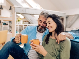 Paar sitzt am Boden und trinkt Kaffee